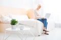 Cheerful aged person working on a laptop while being in a lovely room