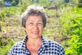 Cheerful aged woman ready to work in home garden