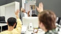 Cheerful aged woman, senior intern waving, saying goodbye to her young colleagues while leaving office after first day