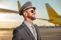 Cheerful aircraft pilot standing outdoors at airport