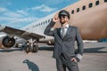 Cheerful aircraft pilot standing outdoors at airport