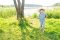 Cheerful angling teenage boy with handmade green twig fishing rod in hand Royalty Free Stock Photo