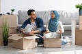 Cheerful arab family unpacking belongings, moving to new apartment