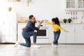 Cheerful arab father dancing with his cute little daughter at home