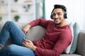 Cheerful arab guy listening to music, using mobile phone Royalty Free Stock Photo