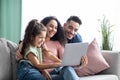 Cheerful arabic family having fun with laptop at home, watching photos together Royalty Free Stock Photo