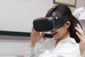 Cheerful Asian business woman wearing virtual reality glasses in office. Royalty Free Stock Photo