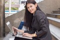 Cheerful asian business woman working on her laptop outdoors Royalty Free Stock Photo