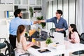 Cheerful Asian businessman partners handshaking with a smile as a symbol of teamwork. Positive multi-ethnic business colleagues.