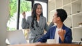 A cheerful Asian businesswoman is celebrating her project success with a male colleague Royalty Free Stock Photo