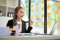 Cheerful Asian businesswoman celebrating her success in her office, looking at laptop screen Royalty Free Stock Photo