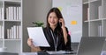 Cheerful Asian businesswoman talking on the phone working in modern office Happy Asian businesswoman company manager Royalty Free Stock Photo