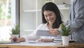 Cheerful asian businesswomen discussing business project with her colleague in bright office Royalty Free Stock Photo