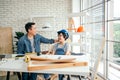 Cheerful Asian carpentry father discusses and teaches his son who wears a safety helmet about construction instruments. Royalty Free Stock Photo