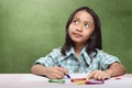 Cheerful asian child imagining something to drawing with crayon Royalty Free Stock Photo