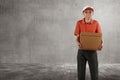 Cheerful asian courier standing with parcel