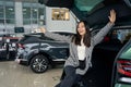 Cheerful asian female rejoices in a new car