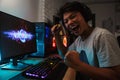 Cheerful asian gamer boy rejoicing victory while playing video g