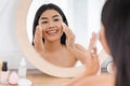 Cheerful asian girl cleaning her face, using cotton pads Royalty Free Stock Photo