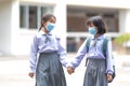 Cheerful Asian kids in student uniforms with medical face masks during pandemic - back to school