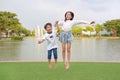 Cheerful Asian little boy and girl kid jumping together with hand in hands at the garden Royalty Free Stock Photo
