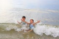 Cheerful Asian little boy and young girl child enjoy playing and lying on tropical sea beach at sunrise. Adorable sister and Royalty Free Stock Photo