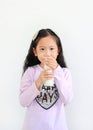 Cheerful asian little child girl drinking milk from glass bottle isolated on white background Royalty Free Stock Photo