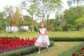 Cheerful asian little girl in white dress running and having fun in the flower garden Royalty Free Stock Photo