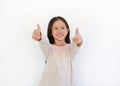 Cheerful Asian little kid girl child pointing at you and looking camera isolated on blue background. Child point two index fingers Royalty Free Stock Photo