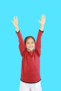 Cheerful asian little kid girl in red long sleeve shirt holding hands up isolated on cyan background. Student question and answer Royalty Free Stock Photo