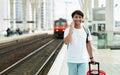 Cheerful asian man tourist walking by train station, talking Royalty Free Stock Photo