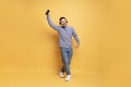 Cheerful asian man in wireless headphones listening music on smartphone and dancing Royalty Free Stock Photo