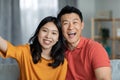 Cheerful asian man and woman taking selfie together at home Royalty Free Stock Photo
