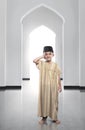 Cheerful asian muslim kid wearing traditional dress praying Royalty Free Stock Photo