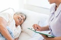 Cheerful Asian nurse talking with elderly patient for monitoring and check up. nurse giving consoling to senior and encourage. Royalty Free Stock Photo