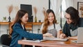 Cheerful Asian small business owners couple meeting with consultant talking about business plan and finance in cafe. Young Royalty Free Stock Photo