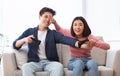 Cheerful Asian Spouses Having Fun Playing Video Game Sitting Indoors Royalty Free Stock Photo