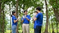 Cheerful Asian volunteers clapped hands to celebrate their successful charity event in the park Royalty Free Stock Photo