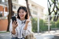 Cheerful Asian woman is looking at her phone with a happy face and showing her fist. lottery winning Royalty Free Stock Photo