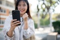 Cheerful Asian woman is looking at her phone with a happy face and showing her fist. lottery winning Royalty Free Stock Photo