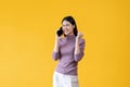 A cheerful Asian woman is talking on the phone with someone, excited after receiving good news Royalty Free Stock Photo