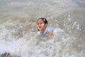 Cheerful Asian young girl child enjoy playing wave on tropical sea beach. Kid having fun in summer holiday Royalty Free Stock Photo