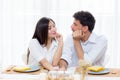 Cheerful asian young man and woman having sitting lunch and talking together at kitchen Royalty Free Stock Photo