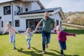 Cheerful ather with his three little daughters holding hands and running in garden. Royalty Free Stock Photo