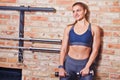 Cheerful athletic girl in sportswear holding metal dumbbells