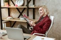 Cheerful attentive woman resting on white office armchair