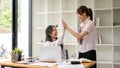 A cheerful Asian businesswoman is giving a high five to her colleague to cheer her up Royalty Free Stock Photo
