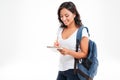 Cheerful attractive asian girl with backpack making notes in notebook Royalty Free Stock Photo