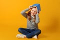 Cheerful attractive little student girl is sitting on the floor with a book on her head. The concept of education and school. Royalty Free Stock Photo