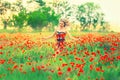 Cheerful attractive pretty girl with blond curly flying hair runs across the poppy field and laughs, the wind blows in Royalty Free Stock Photo